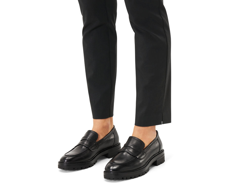 Pieds en pantalon noir et mocassins en cuir.