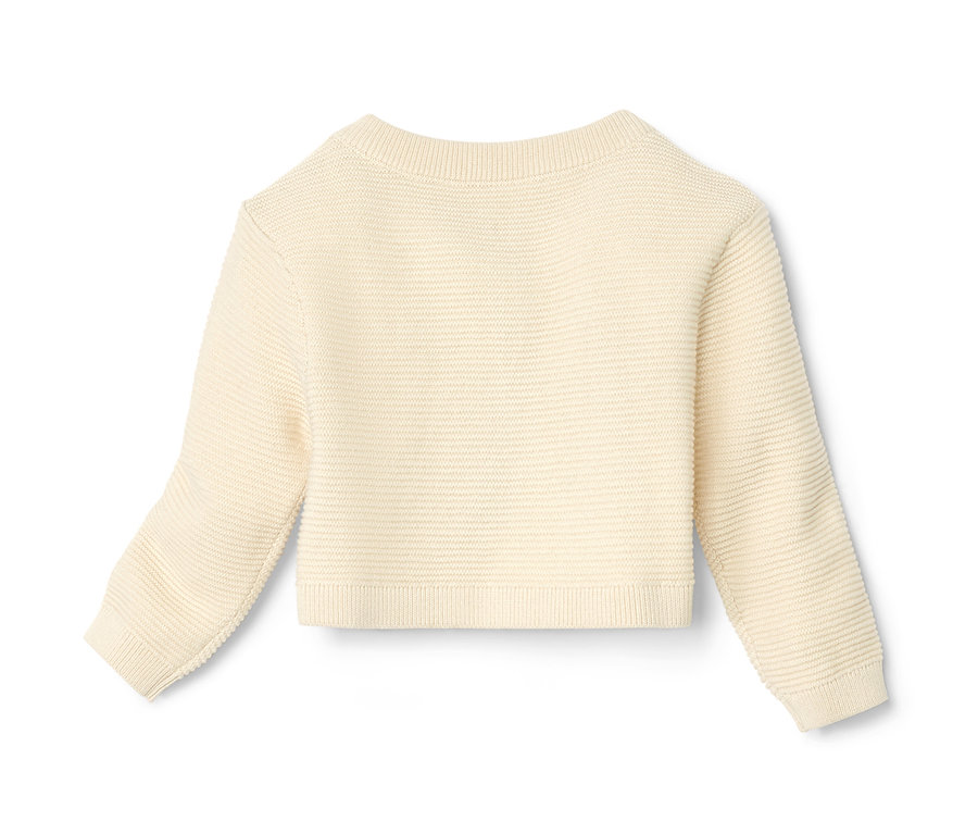Boléro en maille bébé de couleur crème.