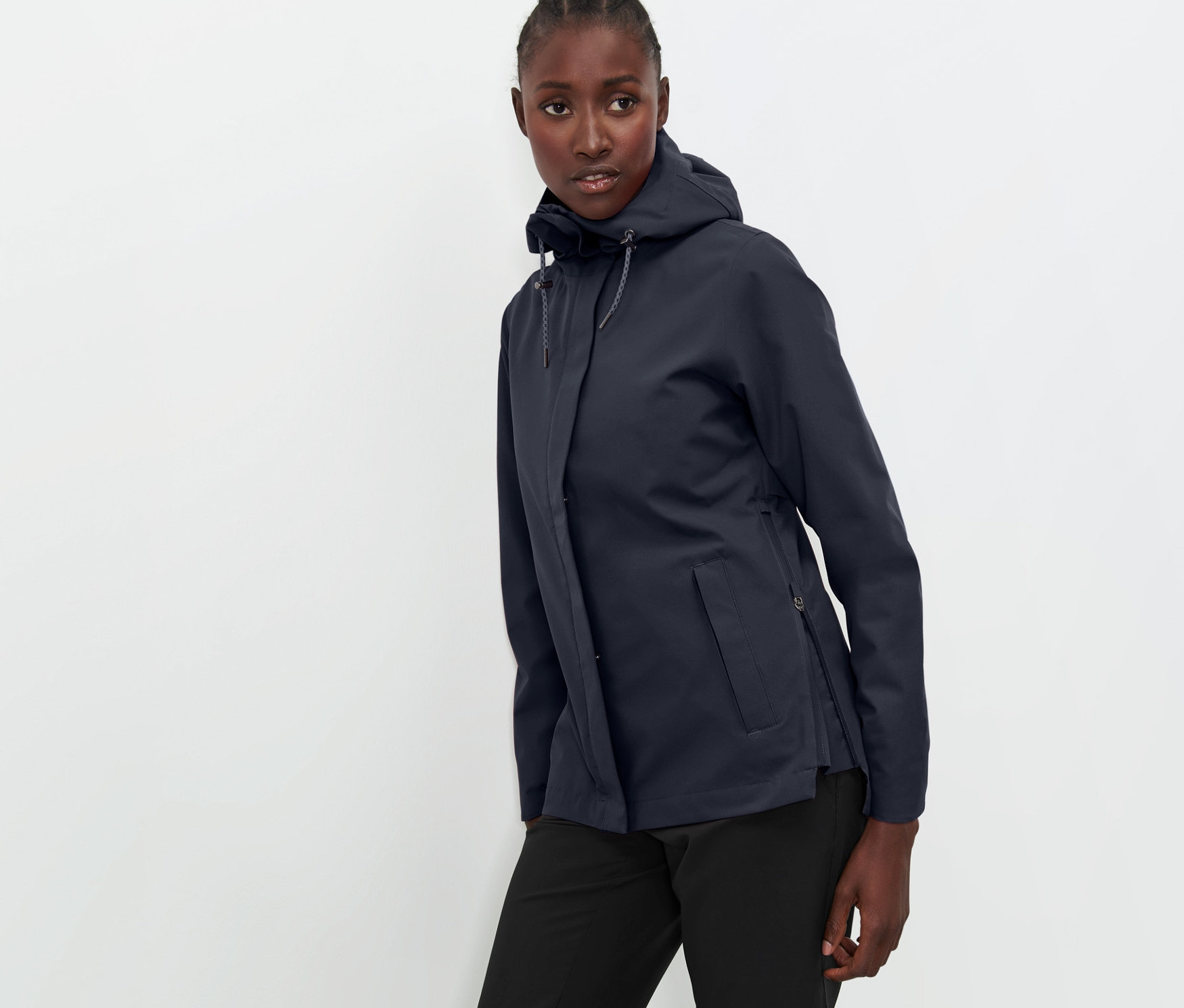 Femme posant en veste technique outdoor bleu marine et pantalon noir.