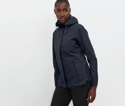 Femme posant en veste technique outdoor bleu marine et pantalon noir.