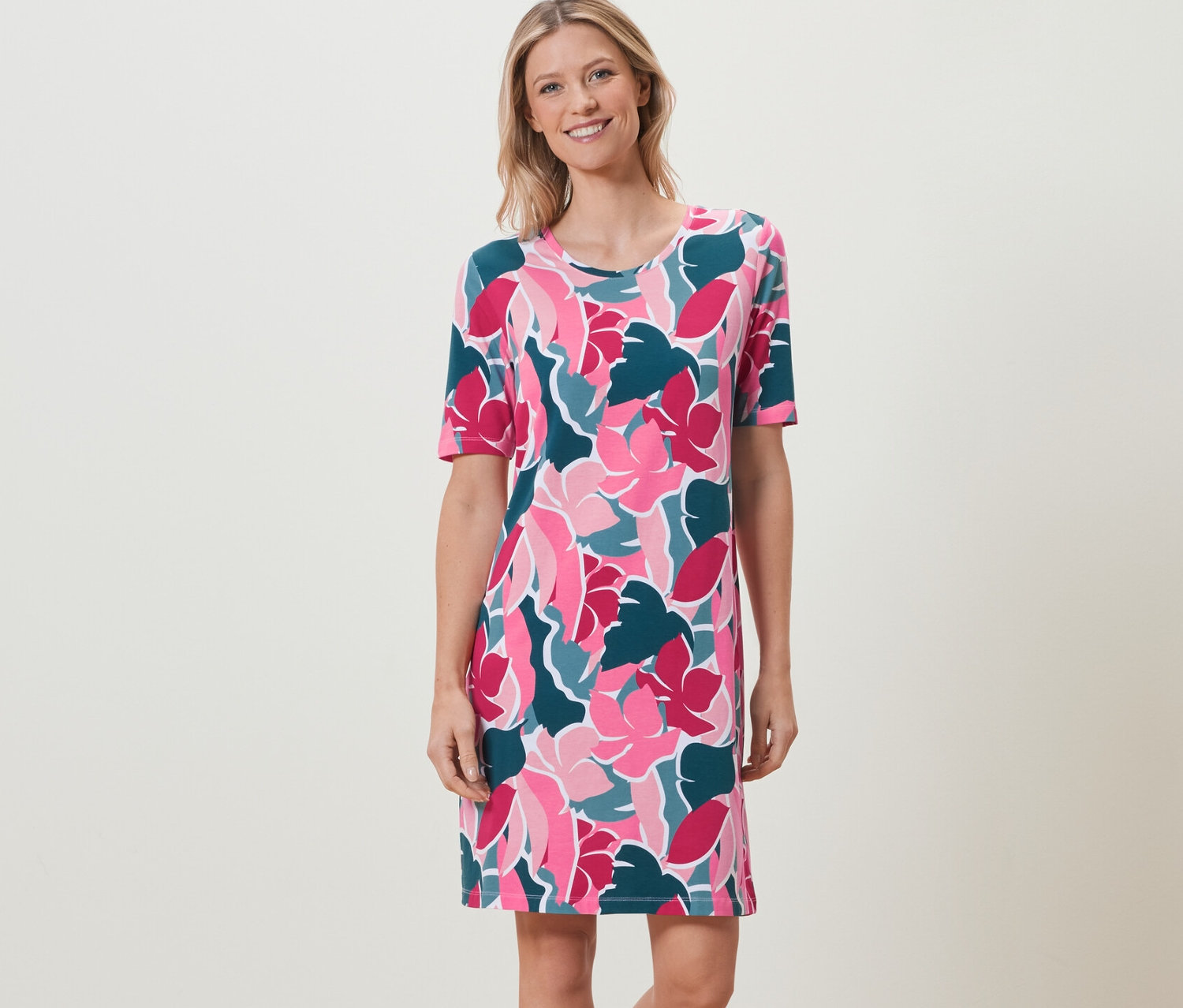 Femme debout portant une chemise de nuit à motif floral.