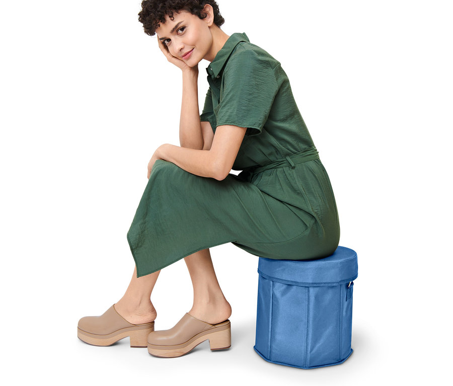 Femme assise sur un sac isotherme 2 en 1 bleu.