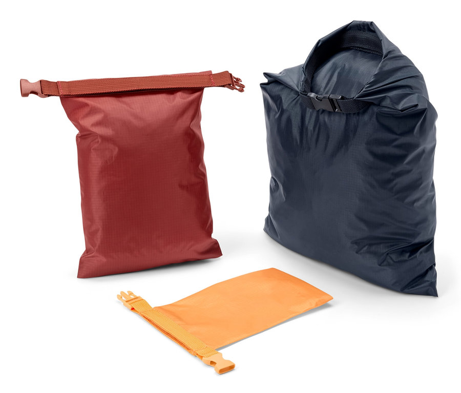 Trois sacs fourre-tout imperméables de couleurs rouge, bleu marine et orange.