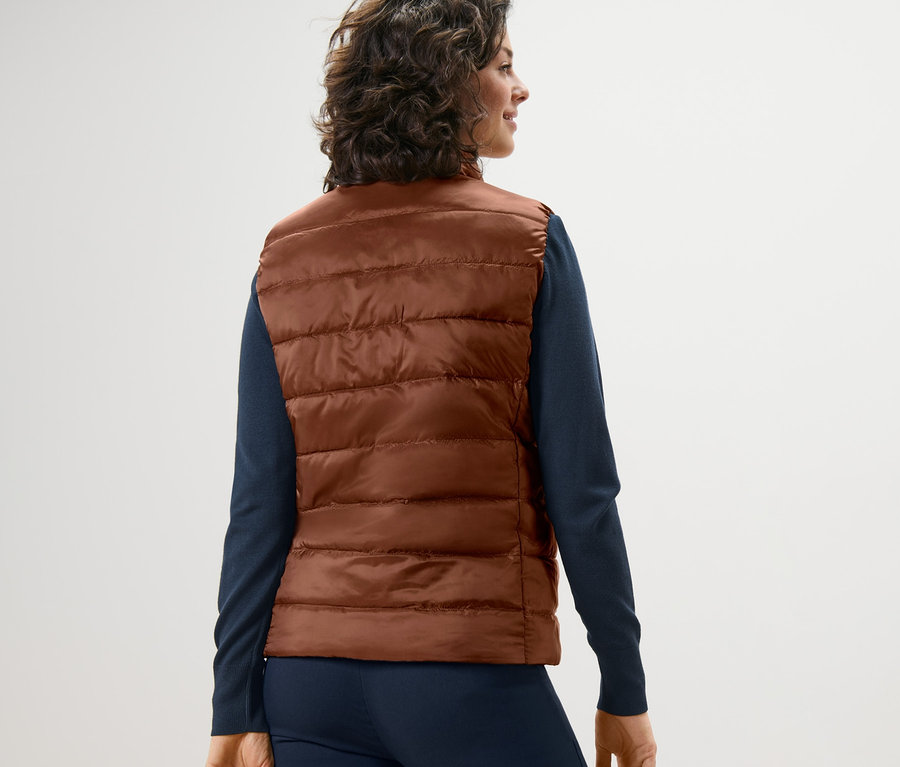 Femme portant un gilet matelassé réversible.