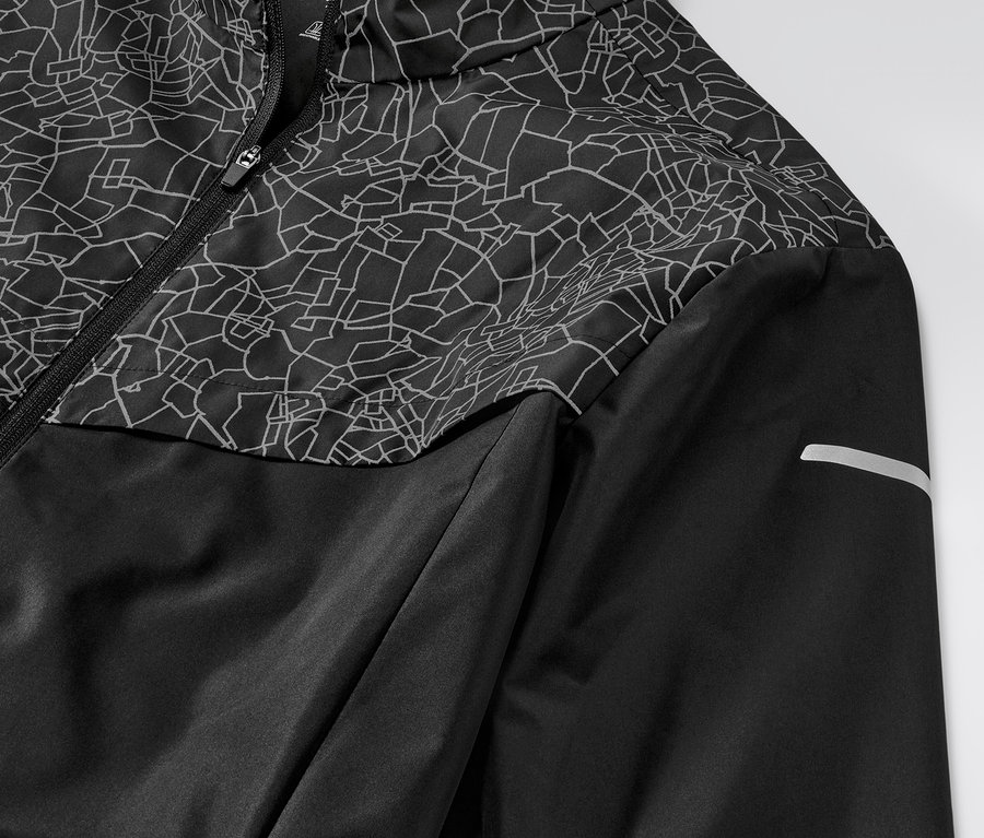 Gros plan sur une veste de sport coupe-vent noire.