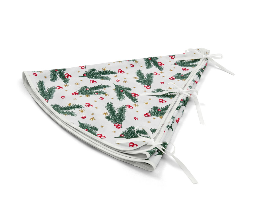 Un couvre-pied de sapin blanc à motifs de sapins de Noël, de baies rouges et d'étoiles dorées.