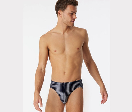 Un homme pose en Supermini SCHIESSER avec coton bio, bleu foncé.