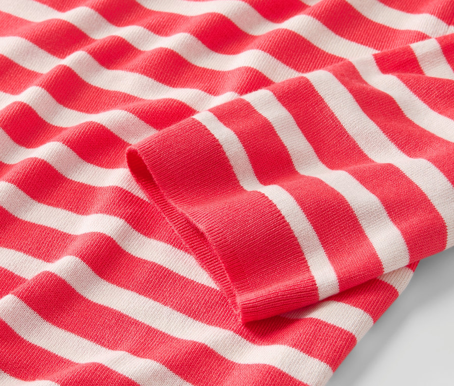 Gros plan sur un pull en maille fine rayé rouge et blanc.