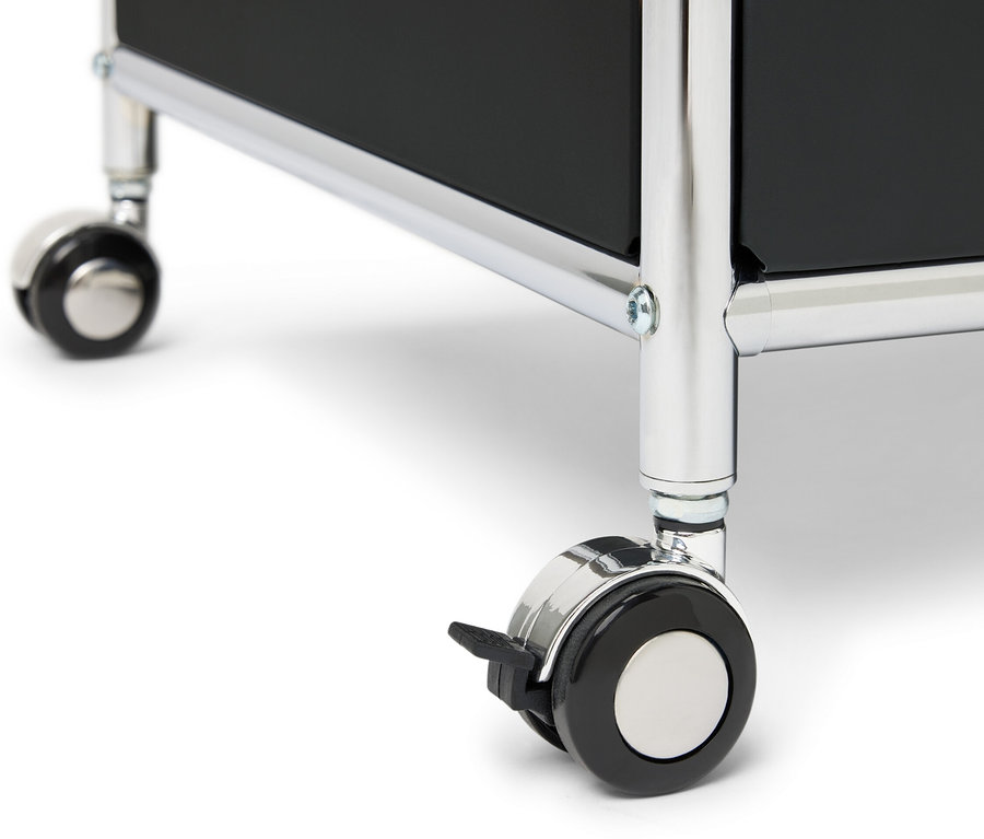 Détail d'une commode métallique « CN3 » avec un tiroir, un compartiment à abattant et un contour, posée sur des roulettes.
