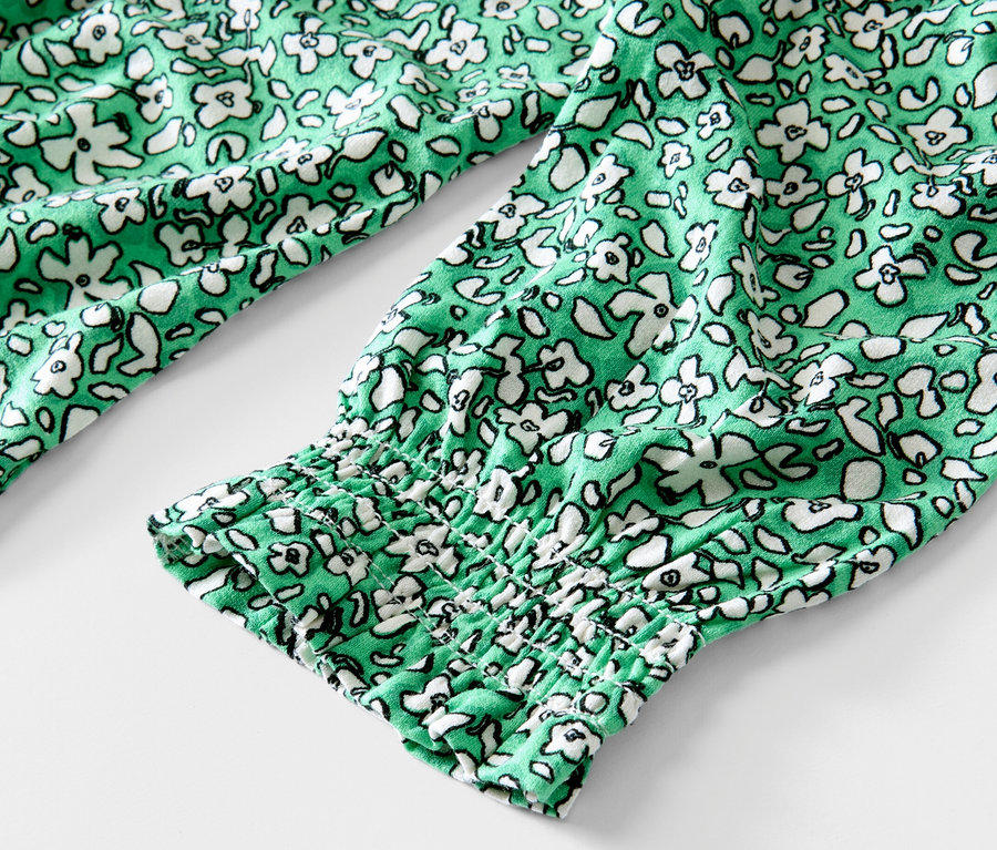 Détail d'une blouse imprimée verte.