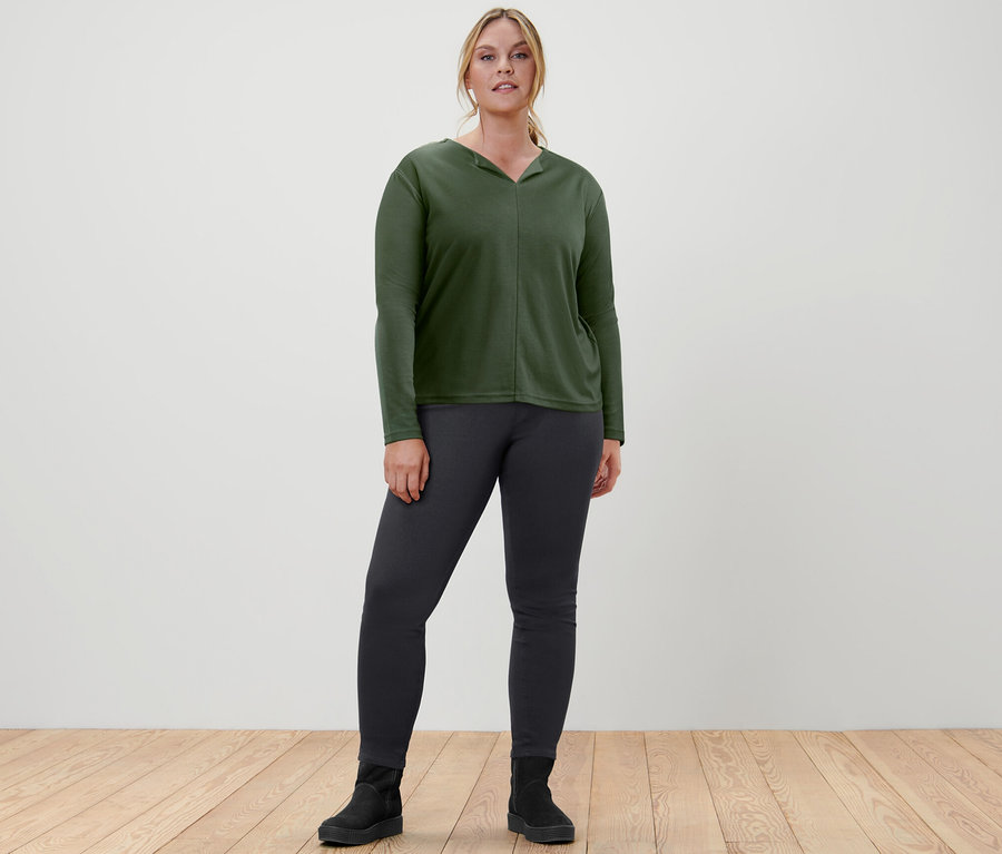 Femme posant en blouse vert foncé et jegging.