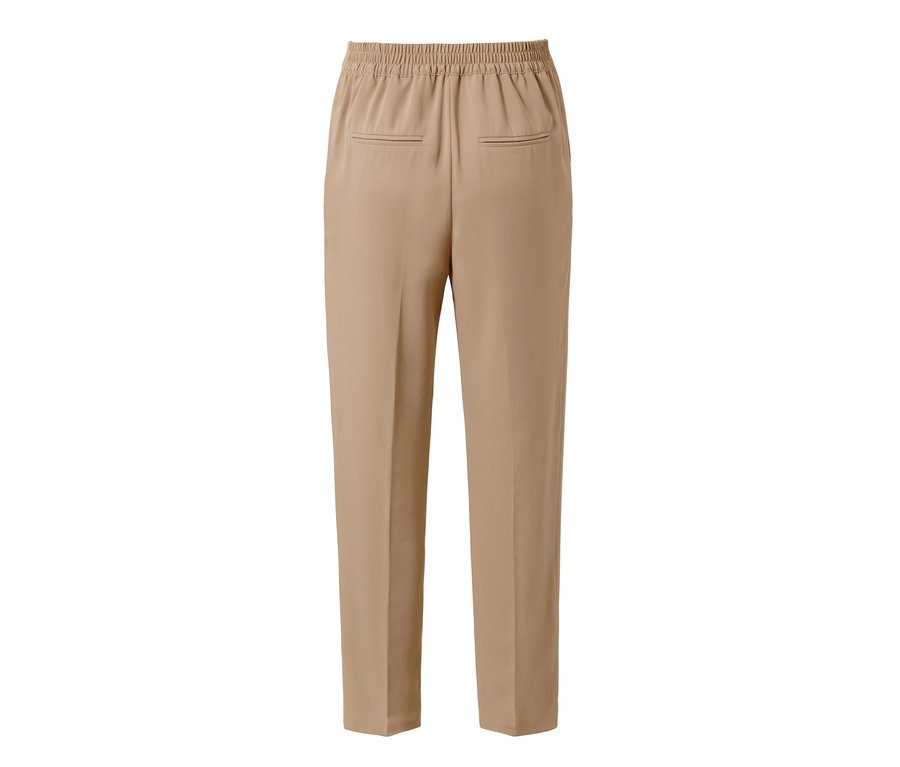 Détail d'un pantalon tissé beige avec passepoil.