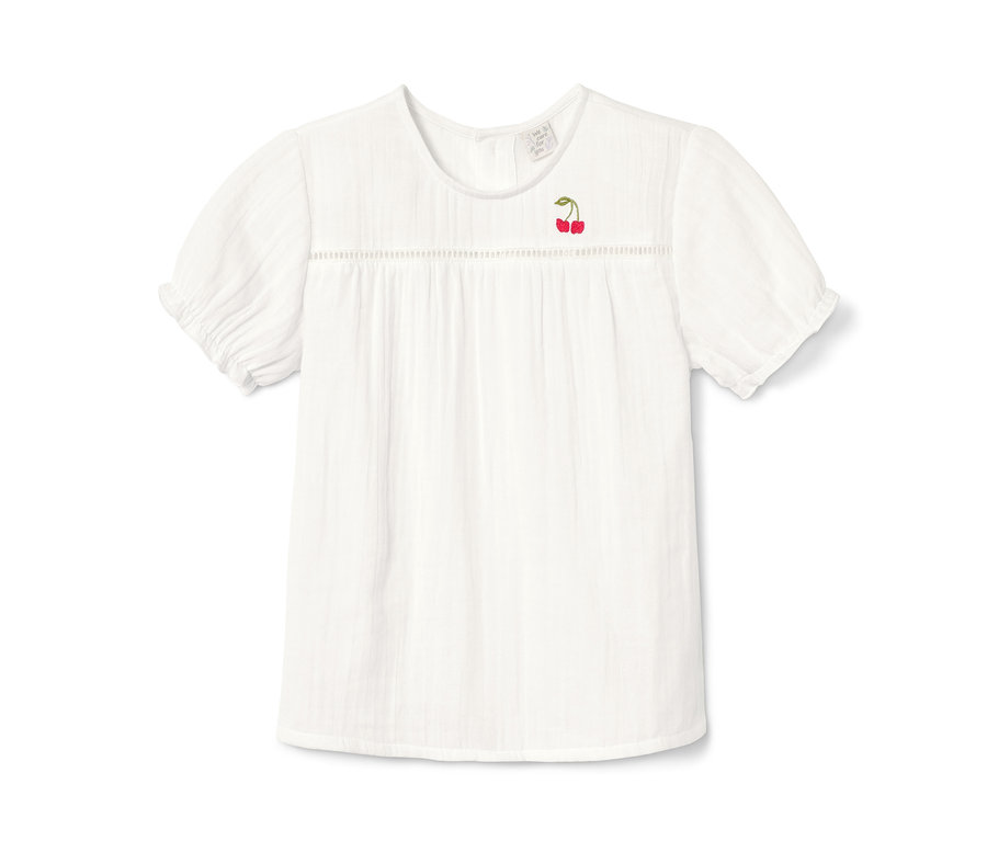 Un chemisier blanc à manches courtes avec une broderie de cerises.