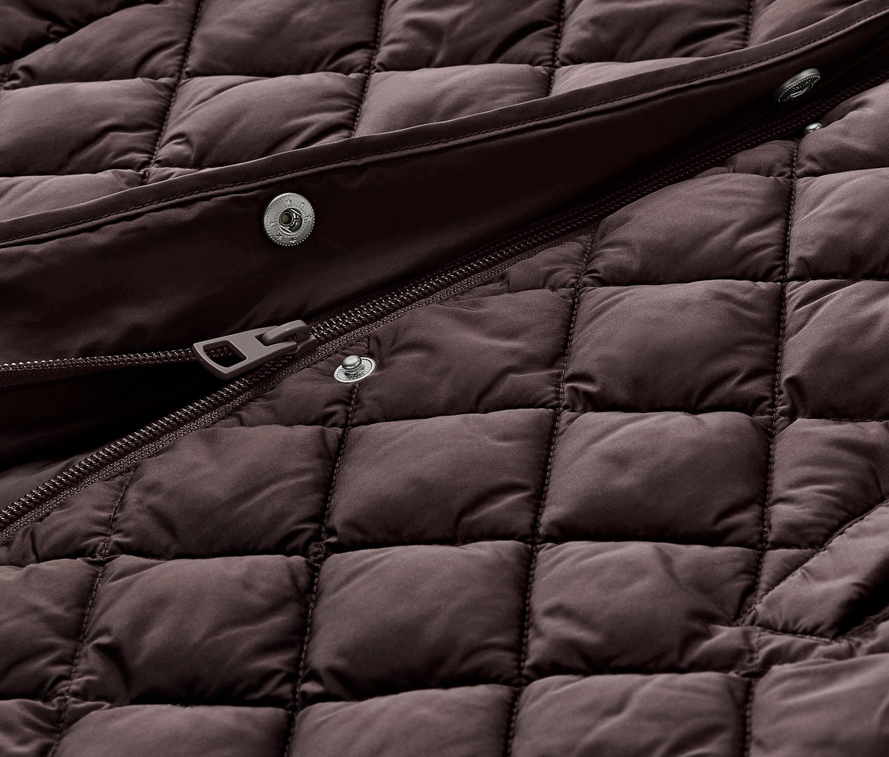 Vue détaillée d'un long gilet matelassé avec capuche, marron foncé.