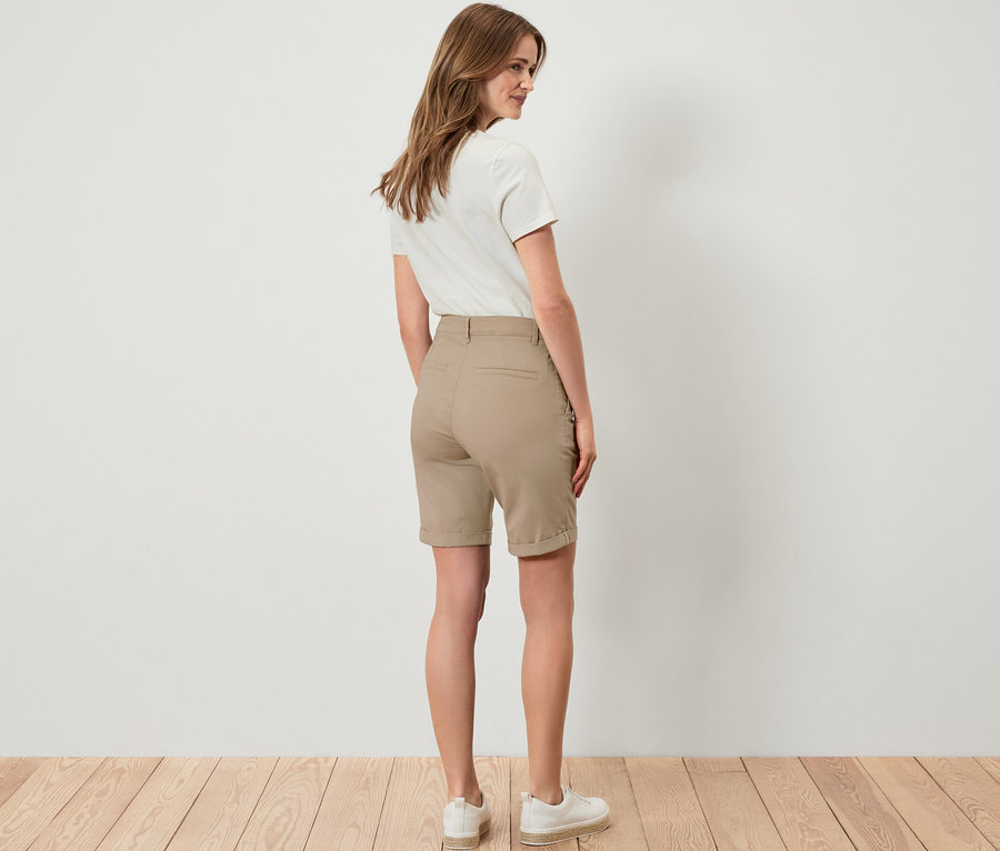 Une femme, vue de dos, porte un short chino beige.