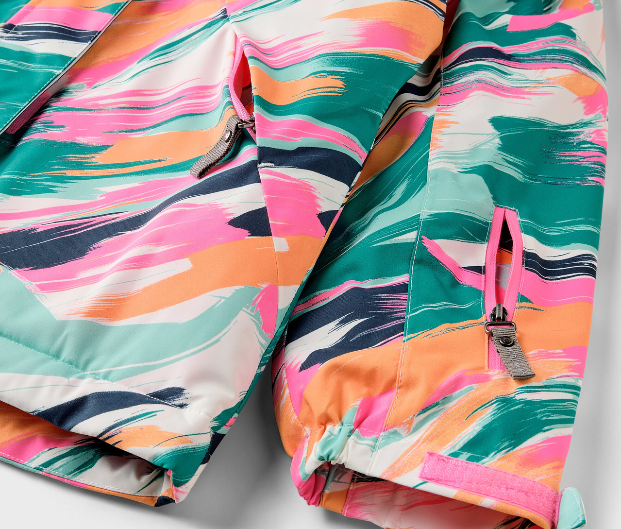 Détail d'une veste colorée avec fermeture éclair.