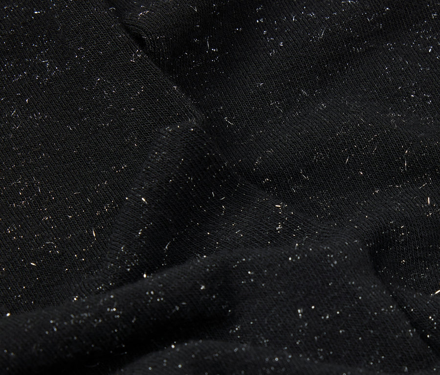 Gros plan d'un tissu noir avec de fines paillettes argentées.