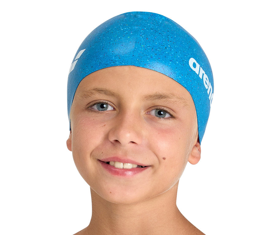 Portrait d'un garçon souriant portant un bonnet de bain arena Junior en silicone bleu.