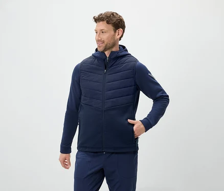 Un homme porte un gilet bleu à capuche et un jogging bleu.