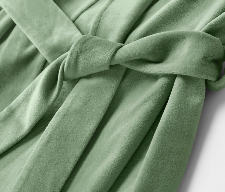 Gros plan sur un peignoir vert clair avec une ceinture nouée.