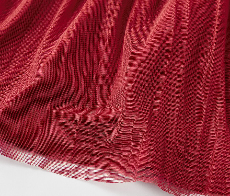Gros plan d'un tissu en tulle bordeaux avec une texture superposée.