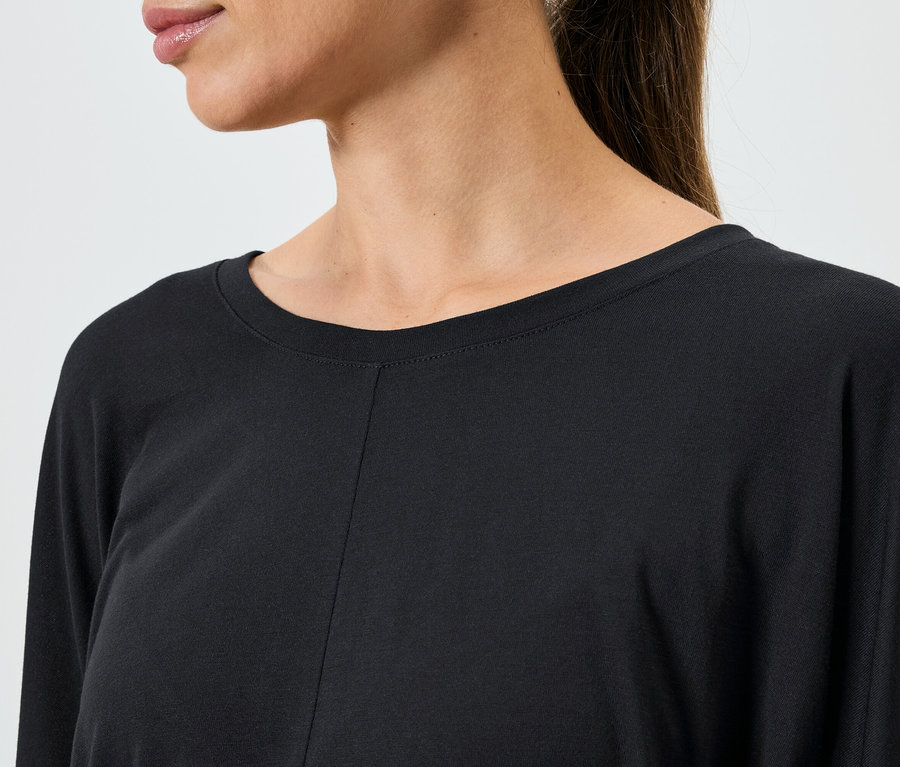 Gros plan d'un haut noir à manches longues pour femme.