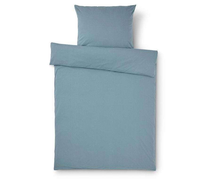 Literie et taie d'oreiller bleu clair sur fond blanc.