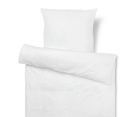 Housse de coussin et de couette blanches texturées.