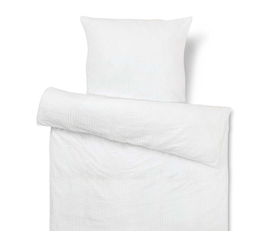 Housse de coussin et de couette blanches texturées.