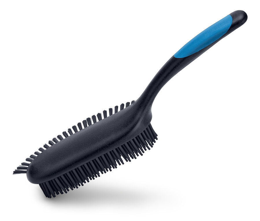 Une brosse noire avec un manche bleu est placée en diagonale sur un fond blanc.