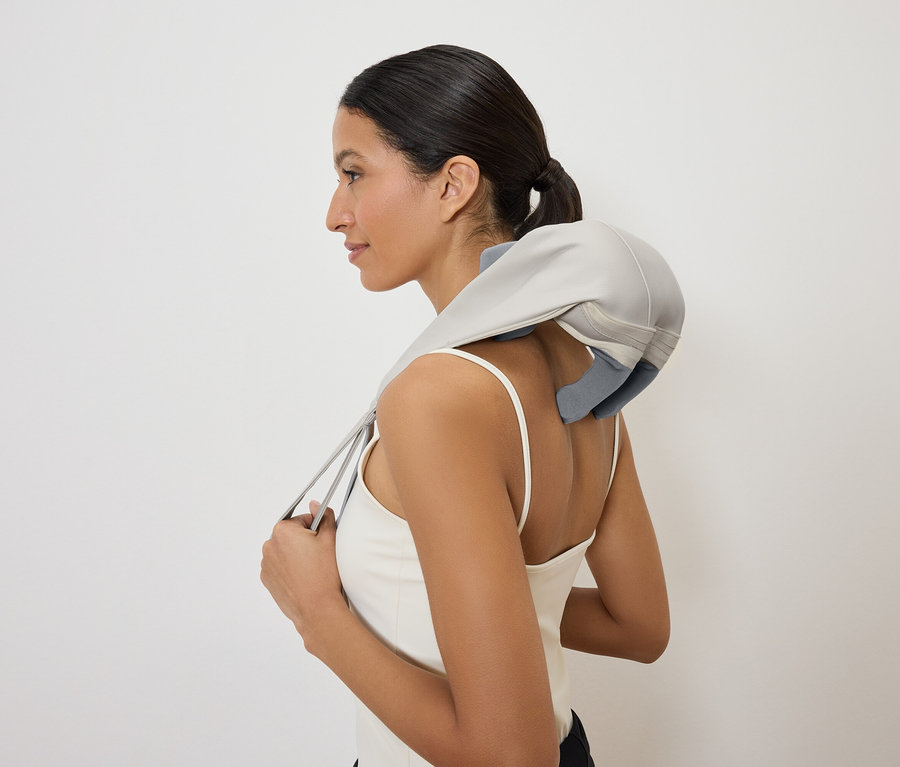 Femme portant un appareil de massage pour le cou, vue latérale.