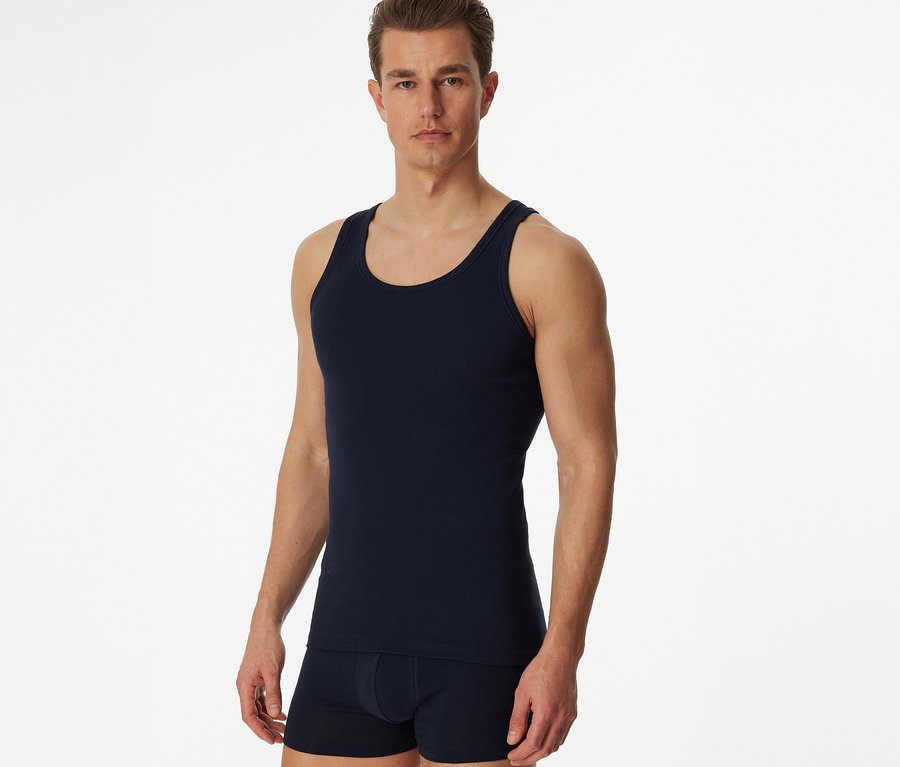 Homme portant un maillot de corps SCHIESSER bleu en maille côtelée fine.