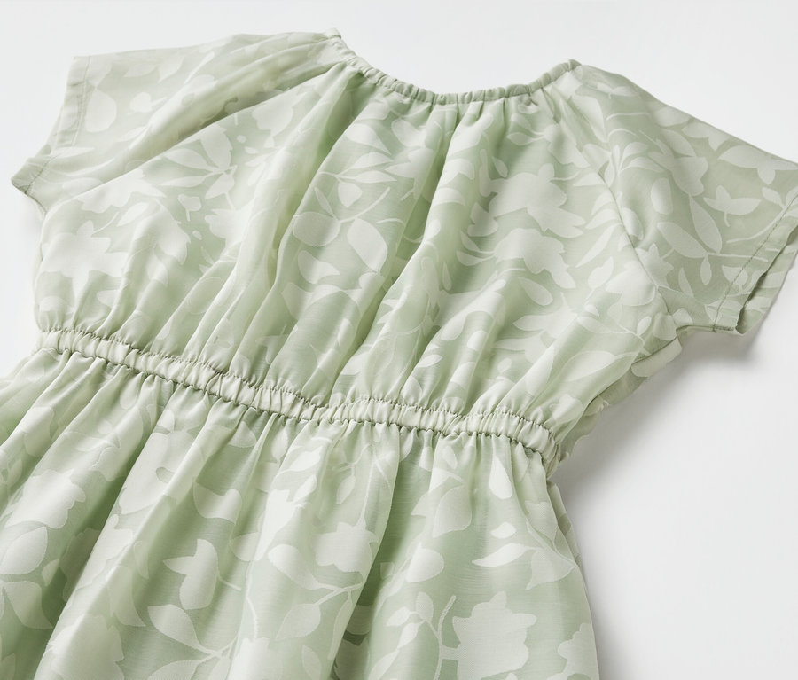 Gros plan d'une robe pour enfant à manches courtes avec un motif floral.