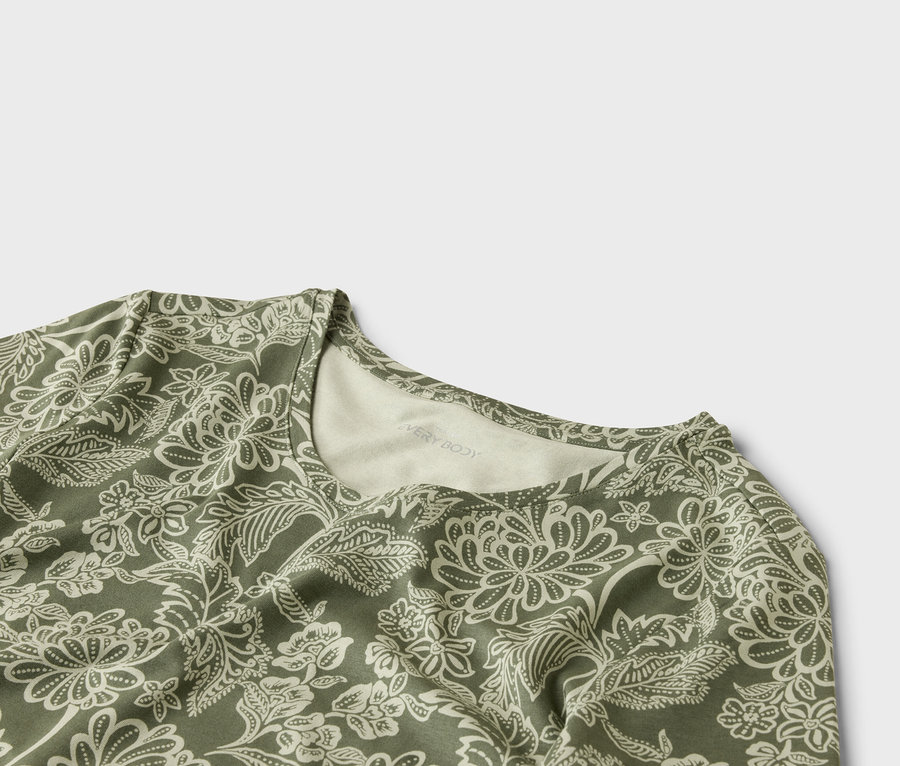 Gros plan d'un haut à motif floral olive et blanc.
