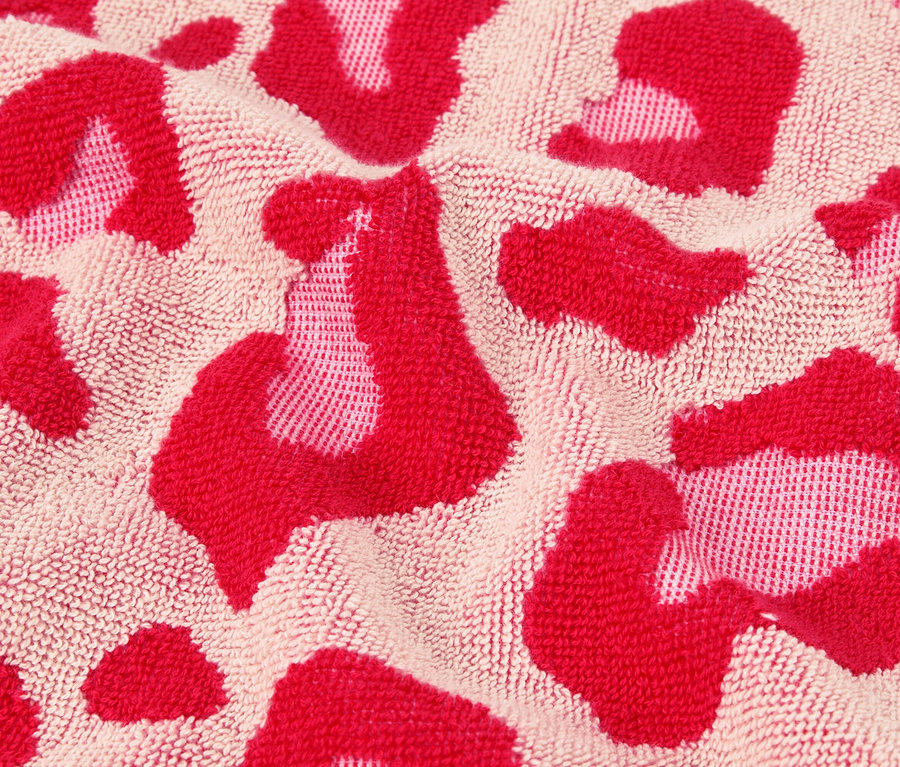 Gros plan d'une serviette avec un motif léopard rose.