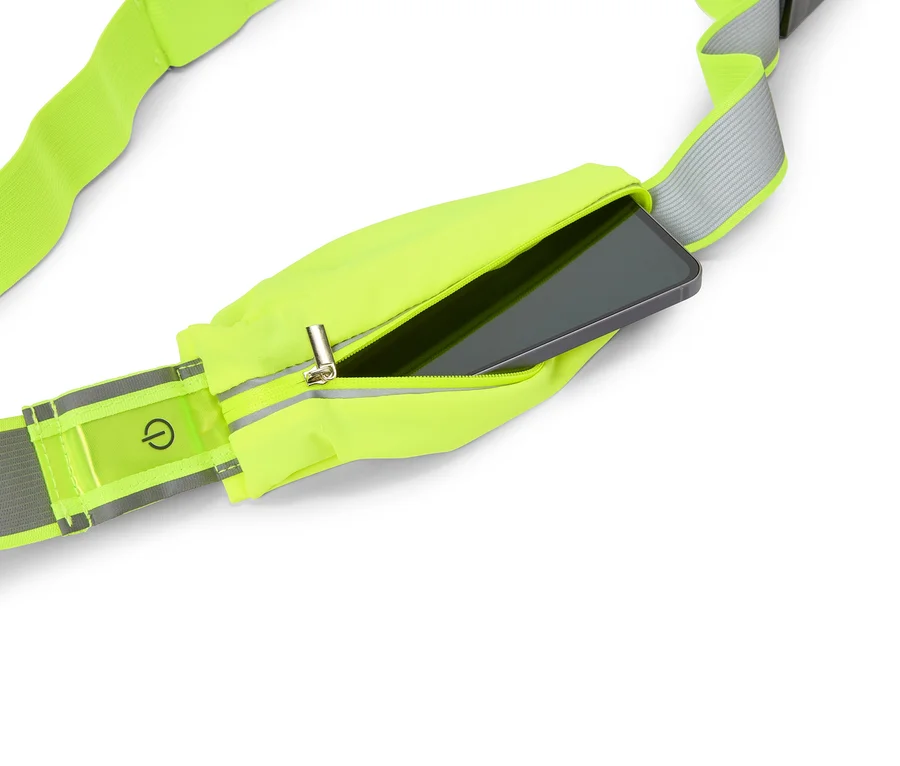 Ceinture de course jaune fluo avec une poche zippée dans laquelle est inséré un smartphone. Un symbole d'interrupteur est visible sur une bande réfléchissante.