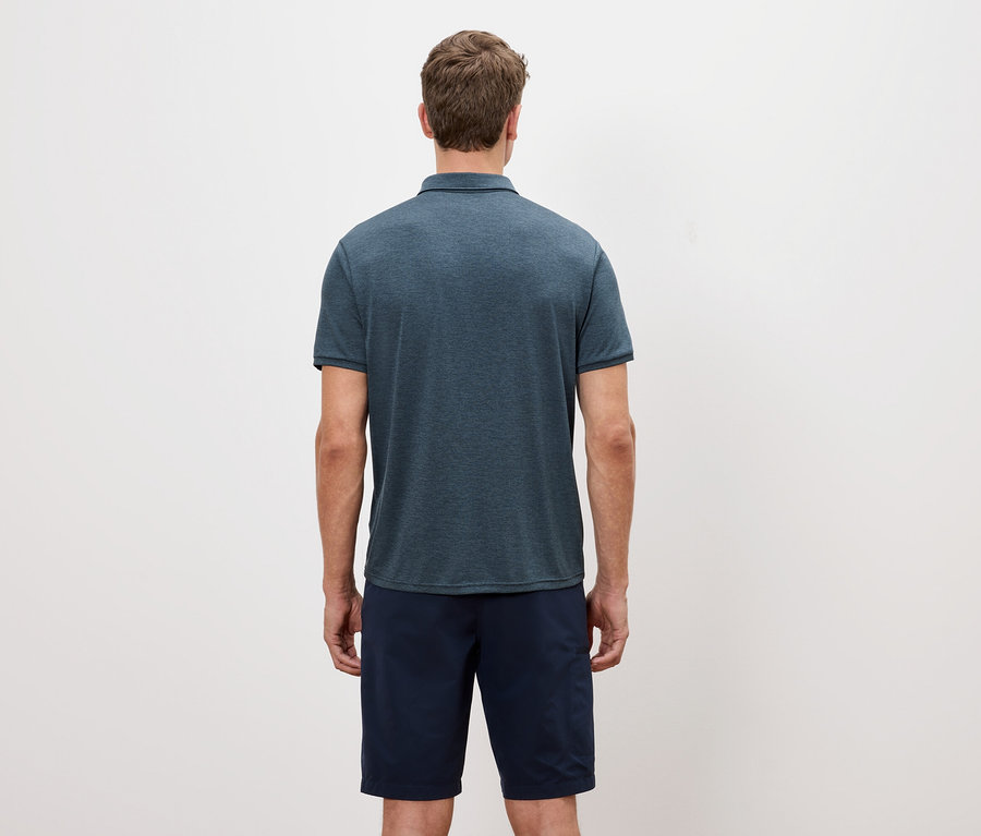 Vue arrière d'un homme portant un polo bleu chiné et un short sur fond blanc.