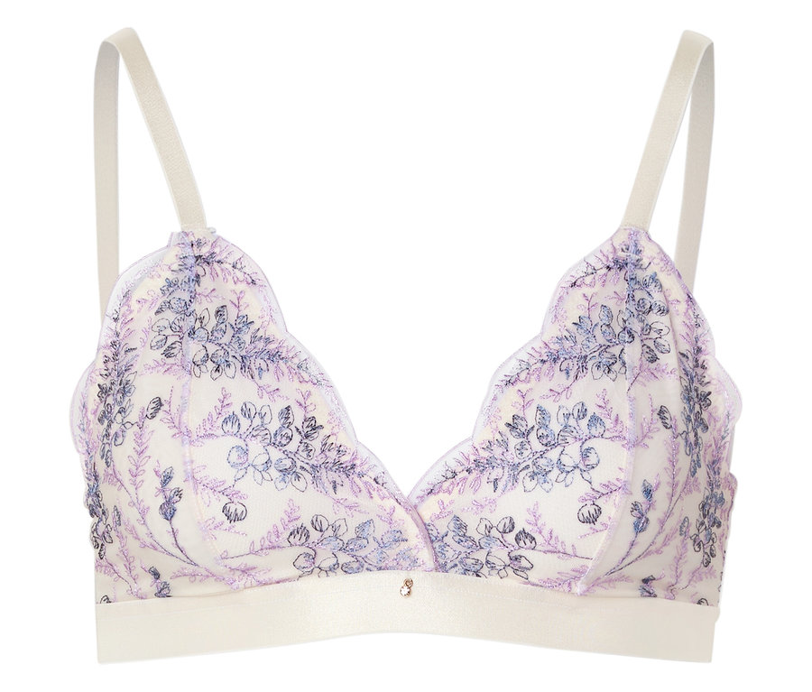 Un soutien-gorge blanc avec un motif floral violet et des bretelles claires repose sur un fond blanc.