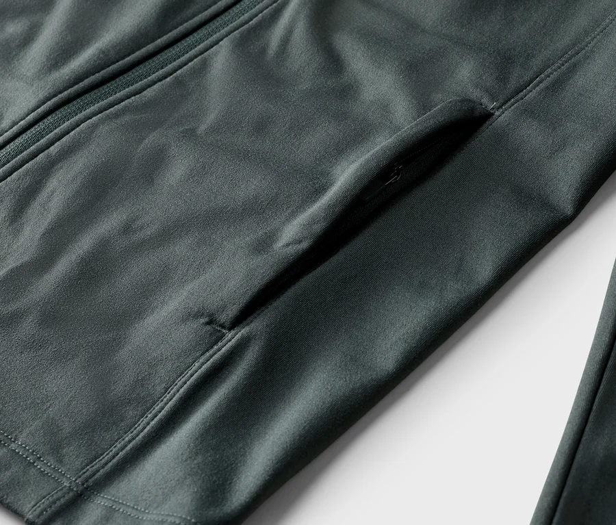 Gros plan d'une veste grise avec une fermeture éclair et une poche zippée.