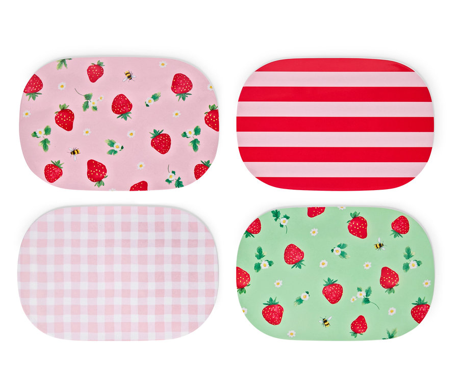 Quatre sets de table sont posés sur un fond blanc. Les sets de table ont des motifs de fraises, de rayures et de carreaux.