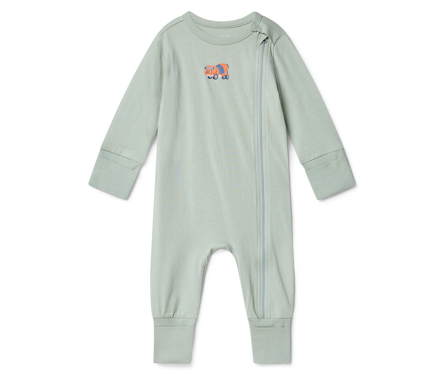 Une grenouillère de bébé vert clair avec un motif de bétonnière orange sur la poitrine est posée sur un fond blanc.