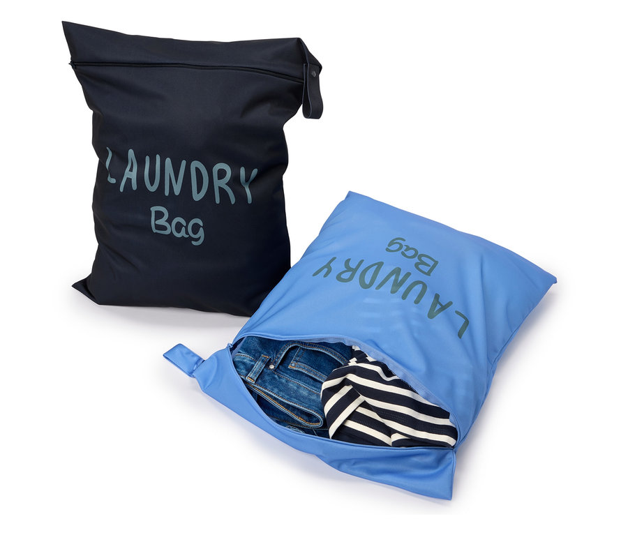 Deux sacs à linge, un noir et un bleu, le bleu étant rempli de jeans et d'une chemise rayée.