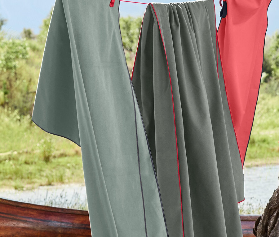 Trois serviettes suspendues à une corde à linge à l'extérieur avec des pinces à linge.