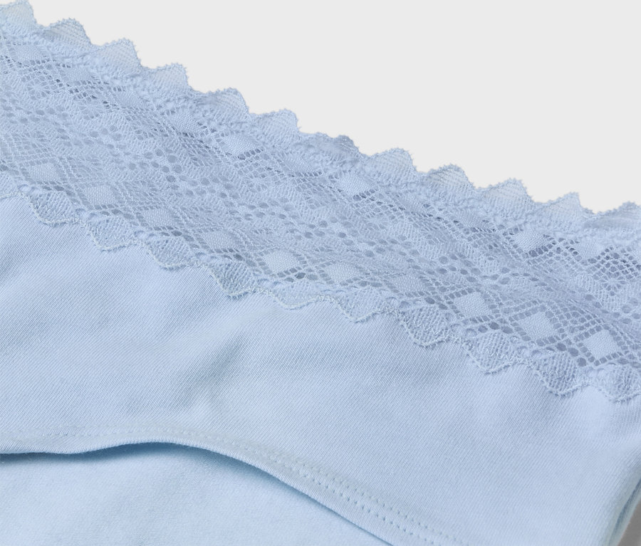 Gros plan sur des sous-vêtements bleu clair avec des détails en dentelle à la taille.