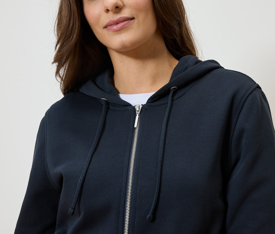 Femme portant un sweat à capuche zippé bleu marine.