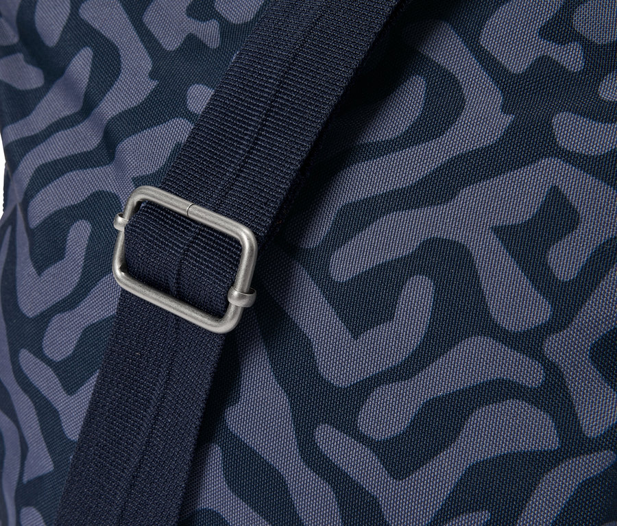 Gros plan d'un sac avec un motif bleu et une fermeture à boucle argentée sur la bandoulière.