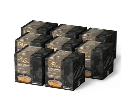 Six boîtes noires de capsules de café Qbo Caffè Grande ESPÍRITO SÃO PAULO de Tchibo, chacune avec 27 capsules, une intensité de 7/10 et des notes de chocolat noir, avec une image de café versé dans un verre.