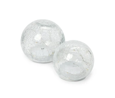 Deux boules décoratives en verre avec une finition argentée craquelée, l'une légèrement plus grande que l'autre, posées côte à côte sur un fond blanc.