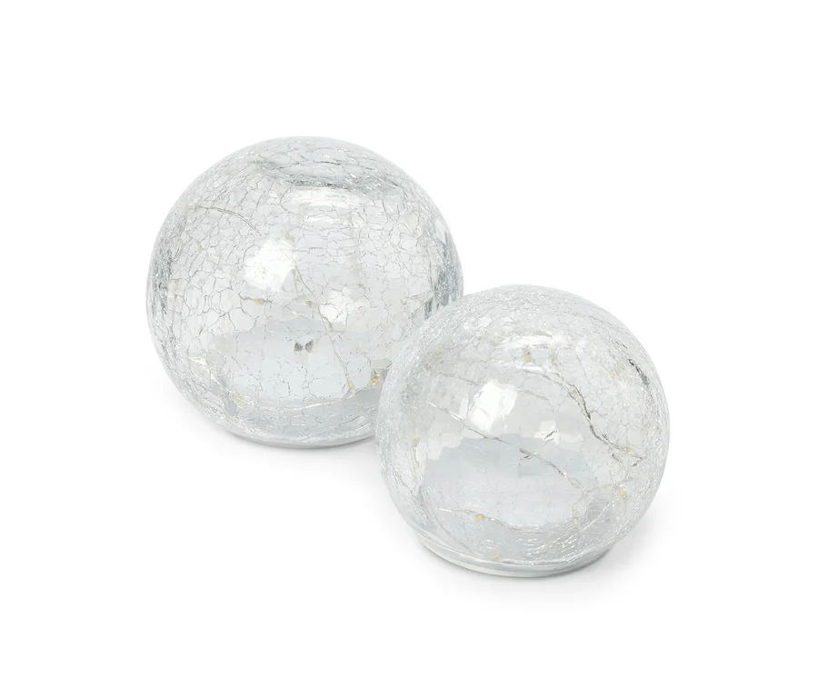 Deux boules décoratives en verre avec une finition argentée craquelée, l'une légèrement plus grande que l'autre, posées côte à côte sur un fond blanc.