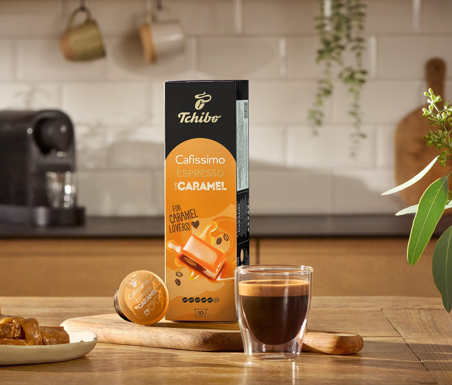 Expresso, caramels mous et un paquet de Flavoured Edition : Espresso Caramel – 80 capsules sur une table en bois.